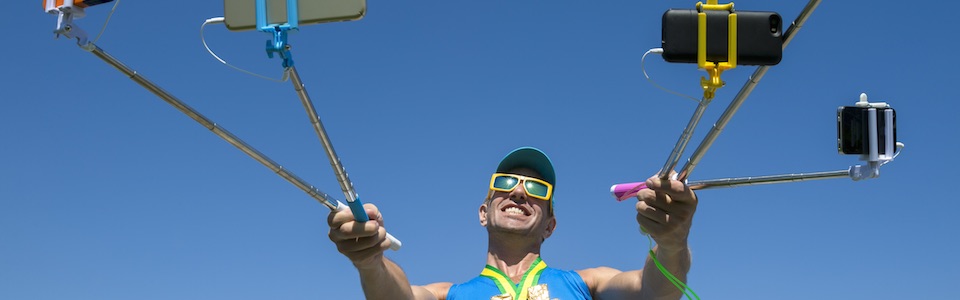 Man holding multiple selfie sticks